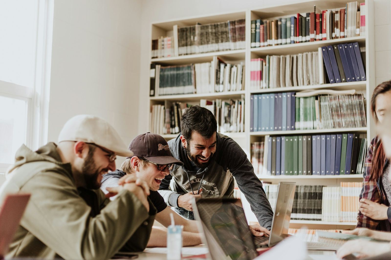 A diverse group of people laughing together while working in a community library