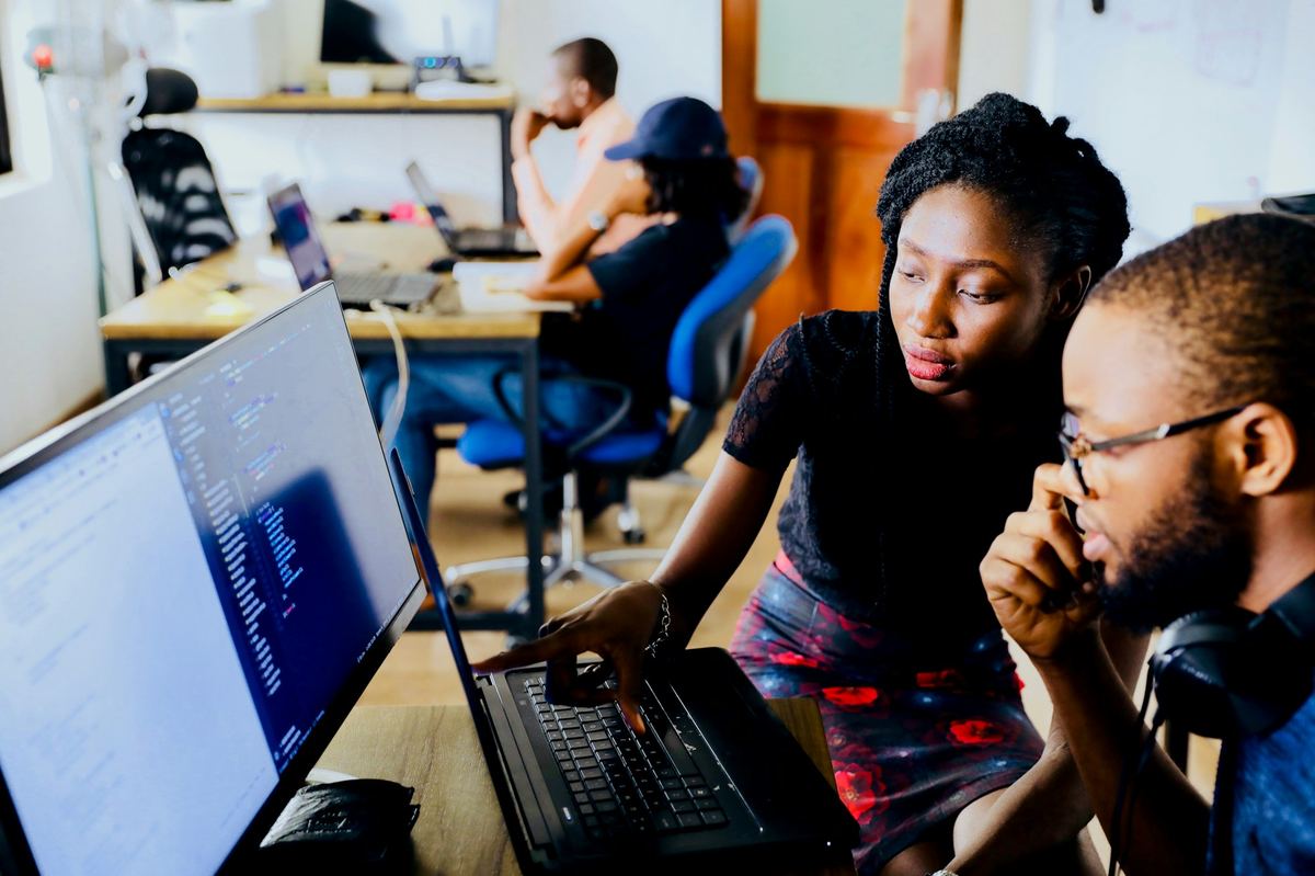 A mentor guiding a colleague through a training session at work